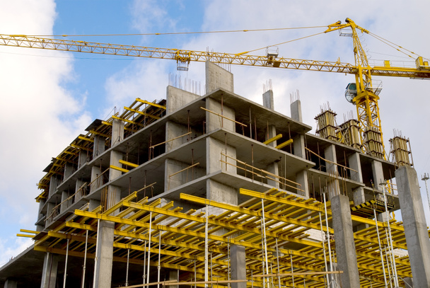 crane near building on cloudly sky background